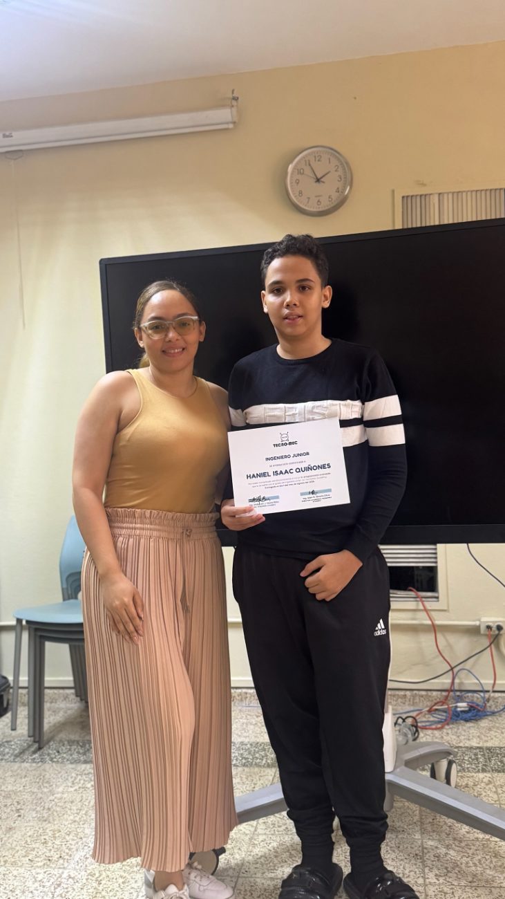 Un estudiante junto a su mamá con el certificado de Ingeniero Junior