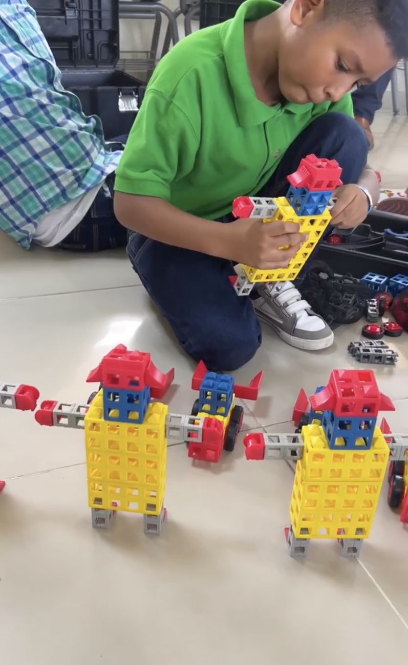 Estudiante construyendo un mecanismo con piezas de ingeniería