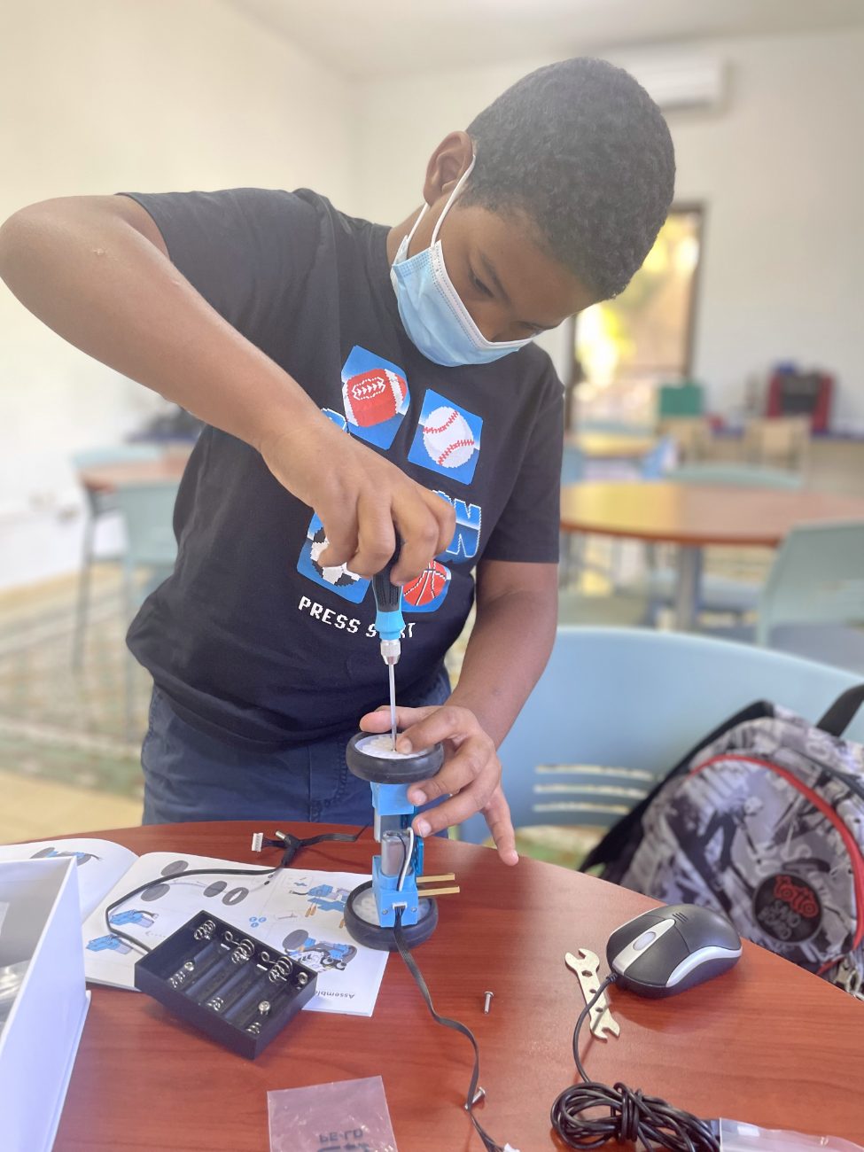 Estudiante atornillando la rueda de su robot