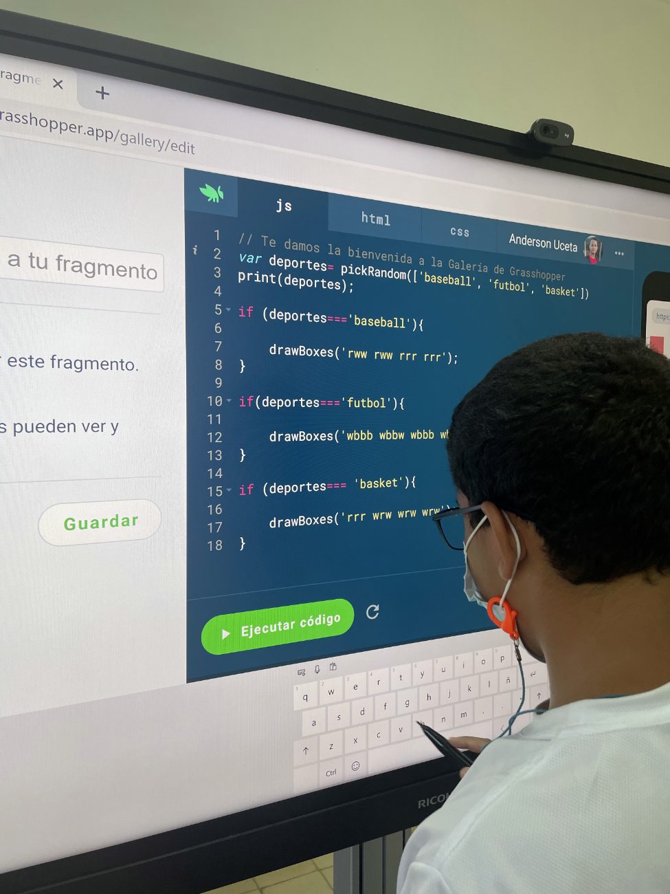 Estudiante escribiendo código JavaScript en una pantalla interactiva